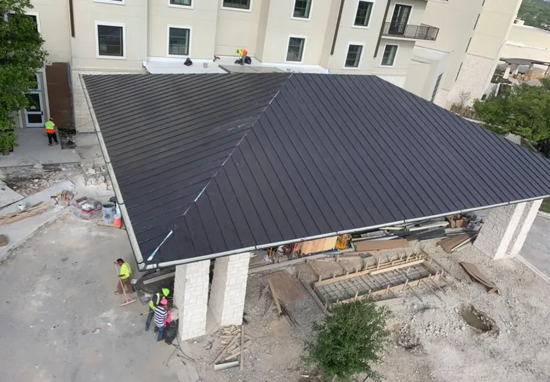 Metal roofing installation team working on a commercial building in Lawrence